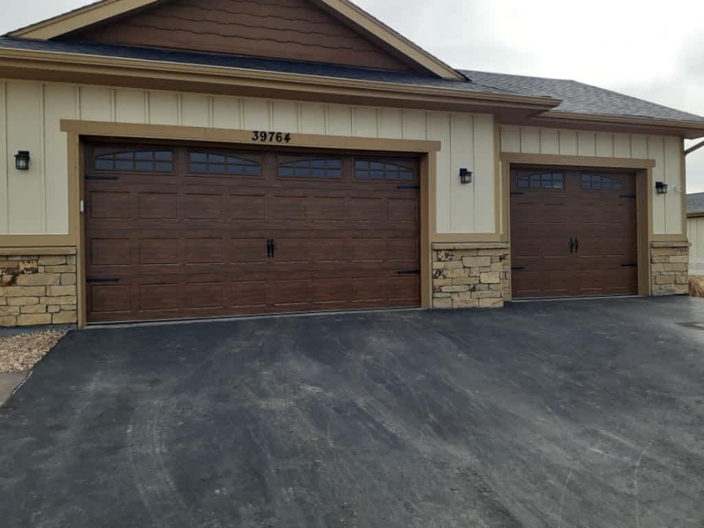 Two new brown garage doors with tan trim