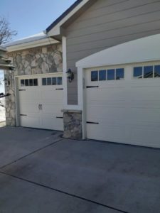 two new garage doors on house with stone finish