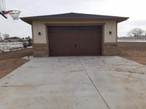 Nice brown finish garage door with stone trim