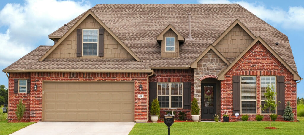 Brown raised panel garage door on a brick house