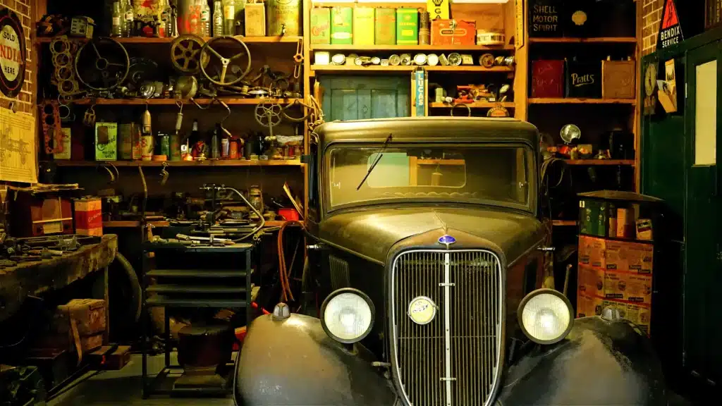 messy disorganized garage with a black antique car