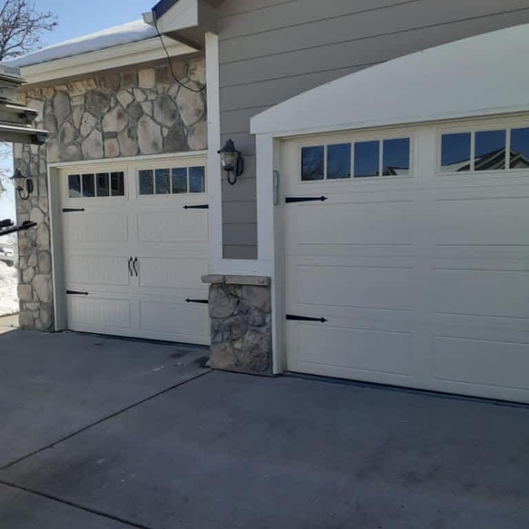 two new garage doors on house with stone finish