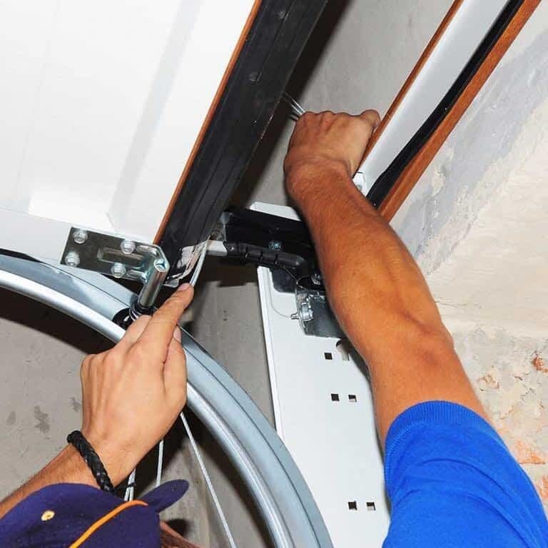Employee fixing spring on garage door
